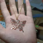 Artisan presenting a butterfly pendant carefully crafted with saw piercing technique
